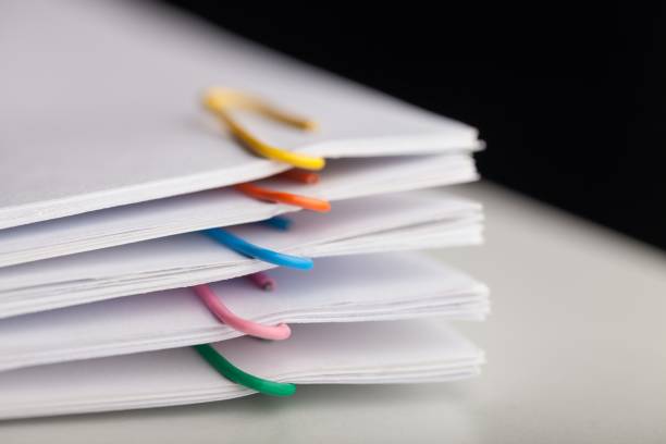 Stack of papers with multicoloured paperclips
